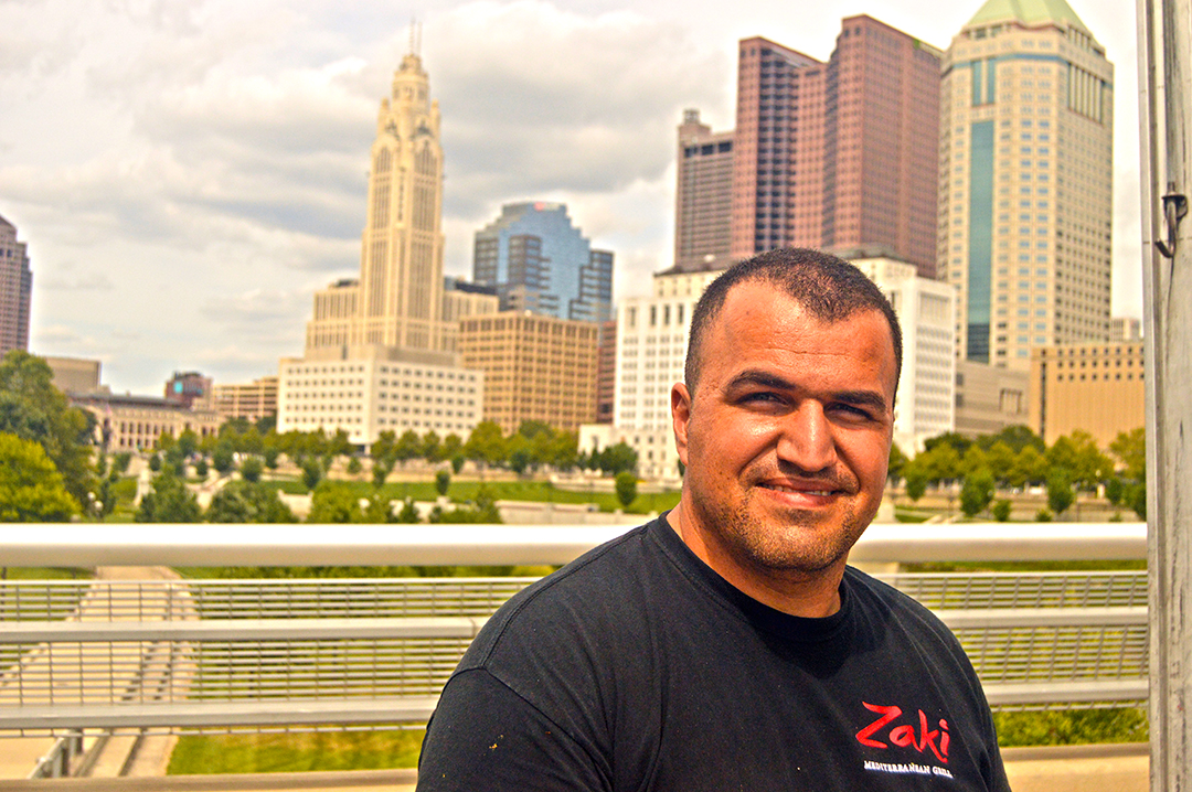 Ahmed Oaraja of Zaki Grill poses in front of buildings, Columbus Food Truck Festival
