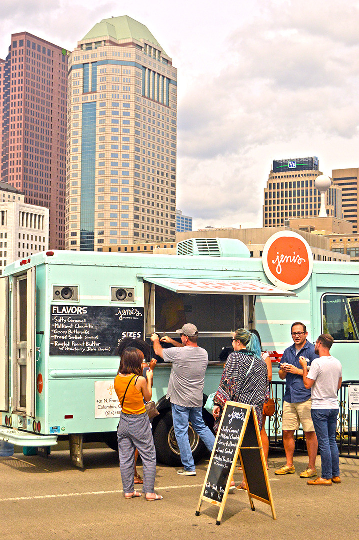 Jeni's Ice Cream vehicle with guests lined up in front of vertical skyline, Columbus Food Truck Festival