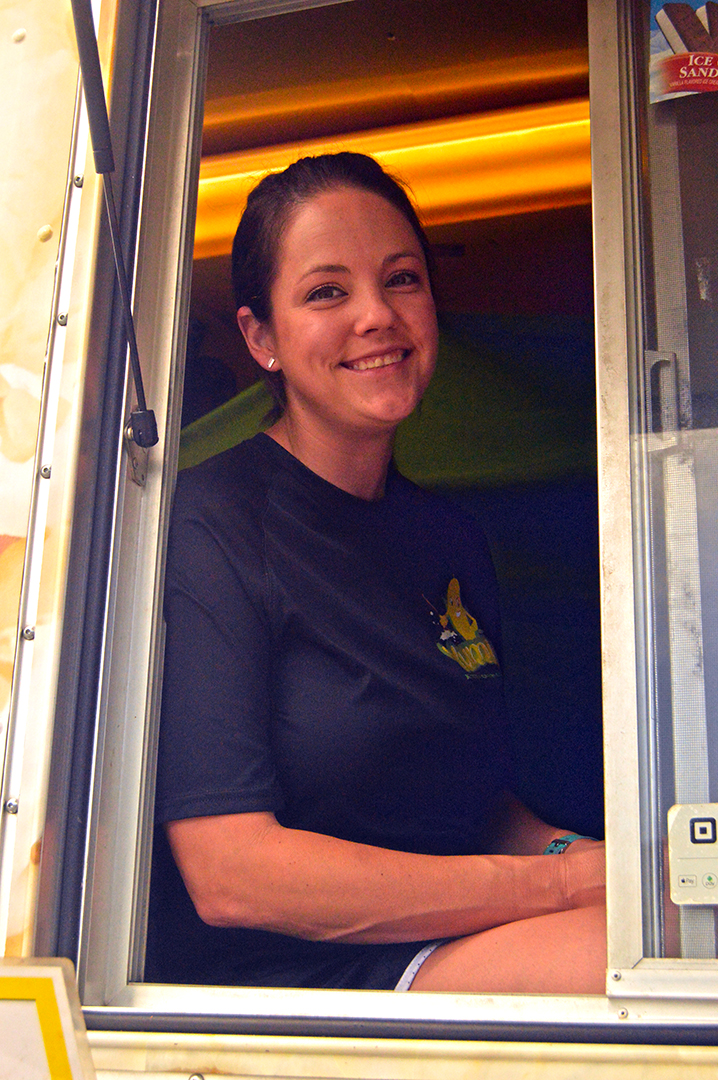 Smiling woman poses from vehicle window, Columbus Food Truck Festival